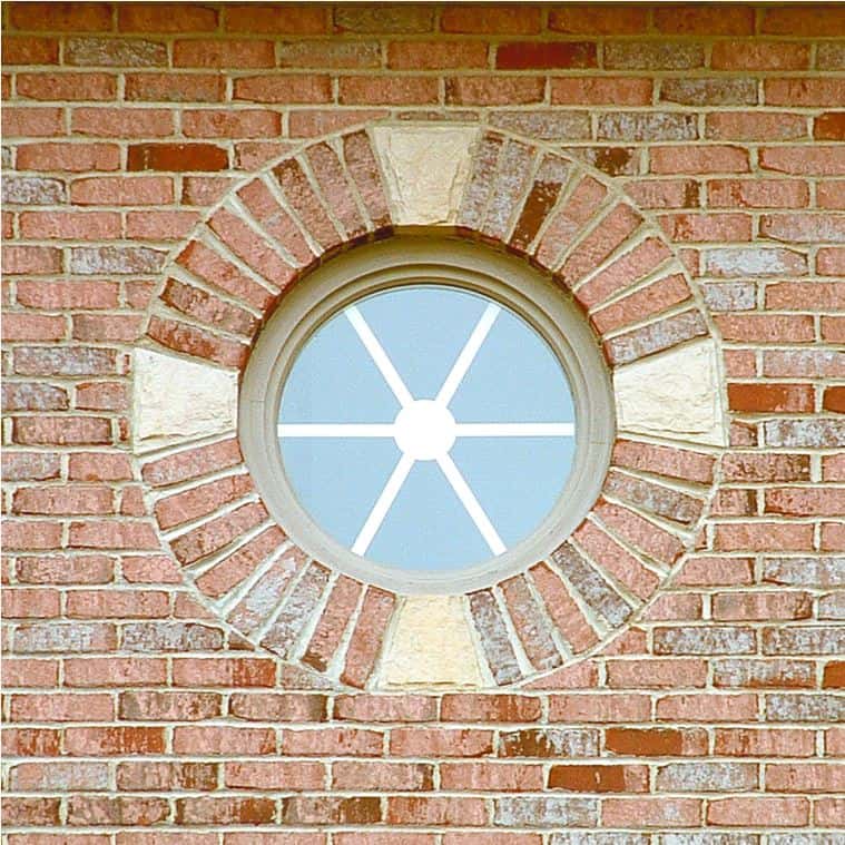 Round custom window on brick wall